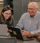 business professor showing a student something on the computer