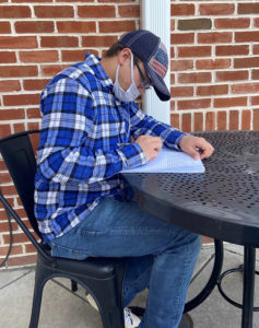 Student studying at an outdoor cafe table. 