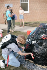 Students painting on the Spirit Rock