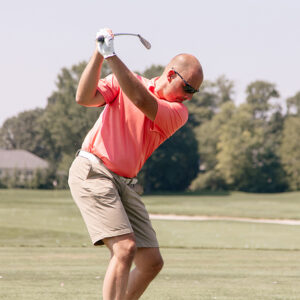 Golf player mid-swing.