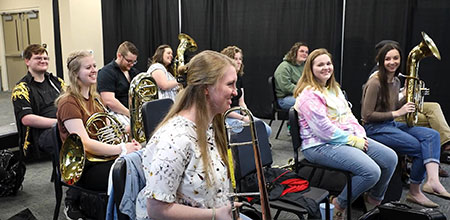 class of music education students learning to play brass instruments