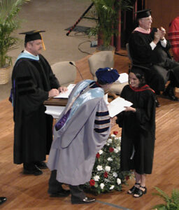 Photo of Dr. Peter W. Teague handing a diploma to a 2001 LBC graduate.