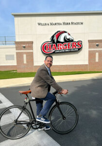 College Pastor Timothy Torres cruises past Herr Stadium on his bike.