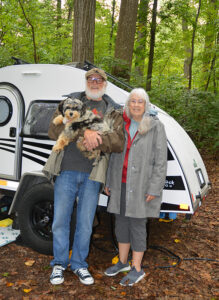phot of Bill and Lynn Shuman, their camper and their dog.