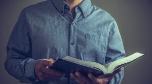 man in blue shirt with bible