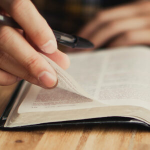 student turning pages of bible