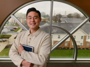 Dr. Matt Lee in front of arched window on LBC campus