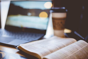 coffee next to a computer and bible