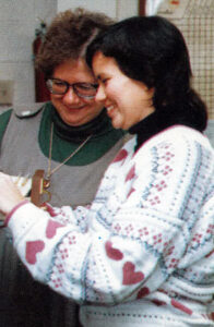 Deb Hunt, left, and Lisa (Dailey '87) Swarr locate information in the library for a student.